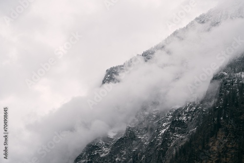 The Beauty of Nature in a Frosty Alpine Landscape. A Misty and Serene View of the Snowy Forest and Mountains in the Alps