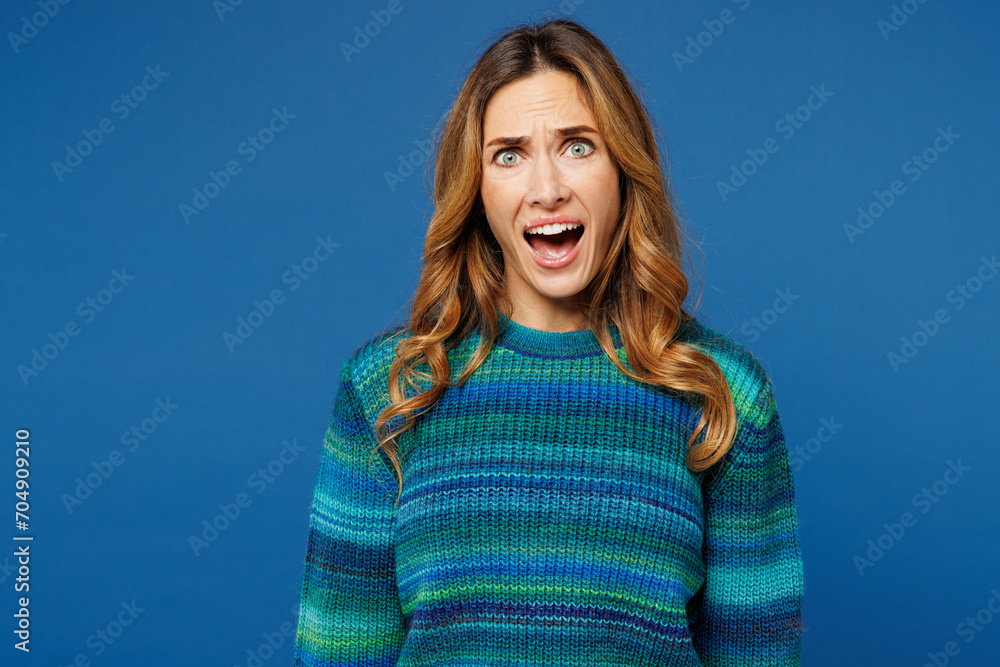 Young sad mad indignant dissatisfied displeased woman she wears knitted sweater casual clothes look camera scream shout isolated on plain blue cyan color background studio portrait. Lifestyle concept.