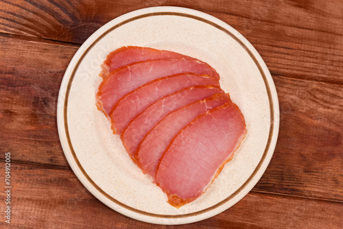 Sliced dry-cured pork loin on saucer, top view