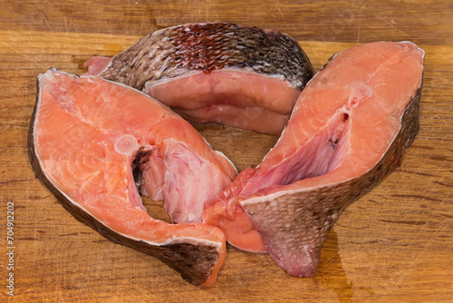 Raw rainbow trout pieces on the wooden cutting board photo