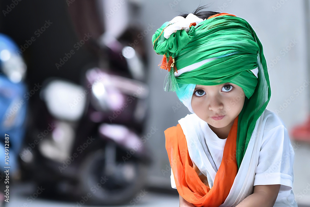 Indian girl wearing tricolor turban and Indian national flag printed t-shirt looking at the camera innocently while celebration Indian national festivals. Indian girl wearing tricolor turban and Indian national flag printed t-shirt looking at the camera innocently while celebration Indian national festivals.