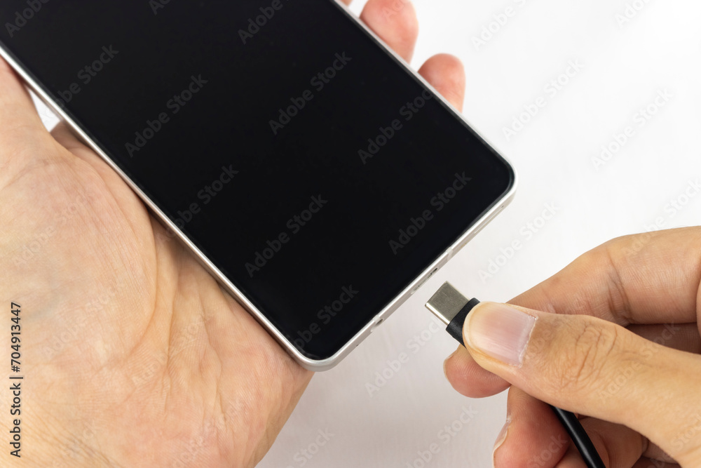 スマホにUSBケーブルを接続する手元(男性、日本人、顔無し)