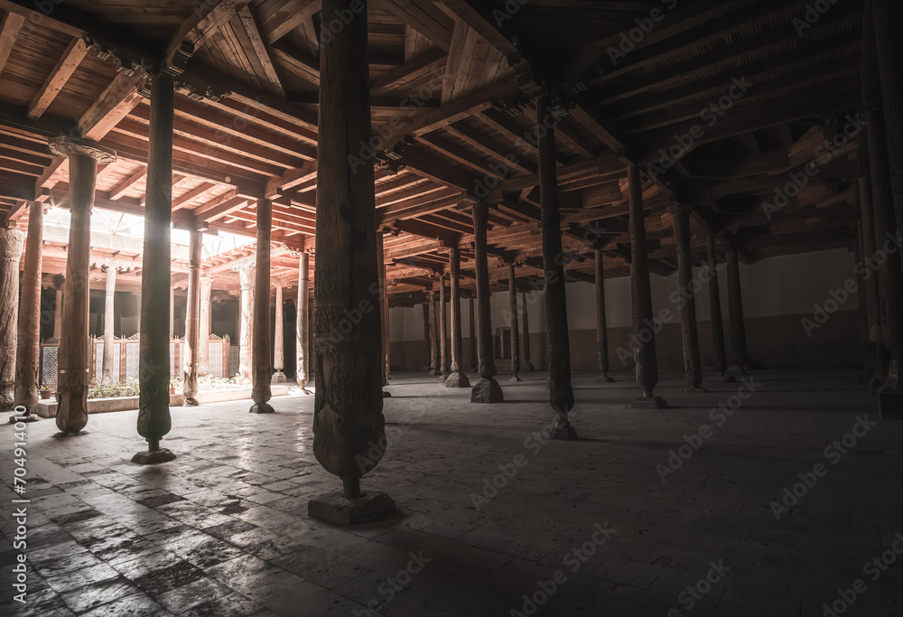 Interior inside the ancient Juma mosque with wooden carved mosaic columns, in the ancient city of Khiva in Khorezm, wood carvings on the columns