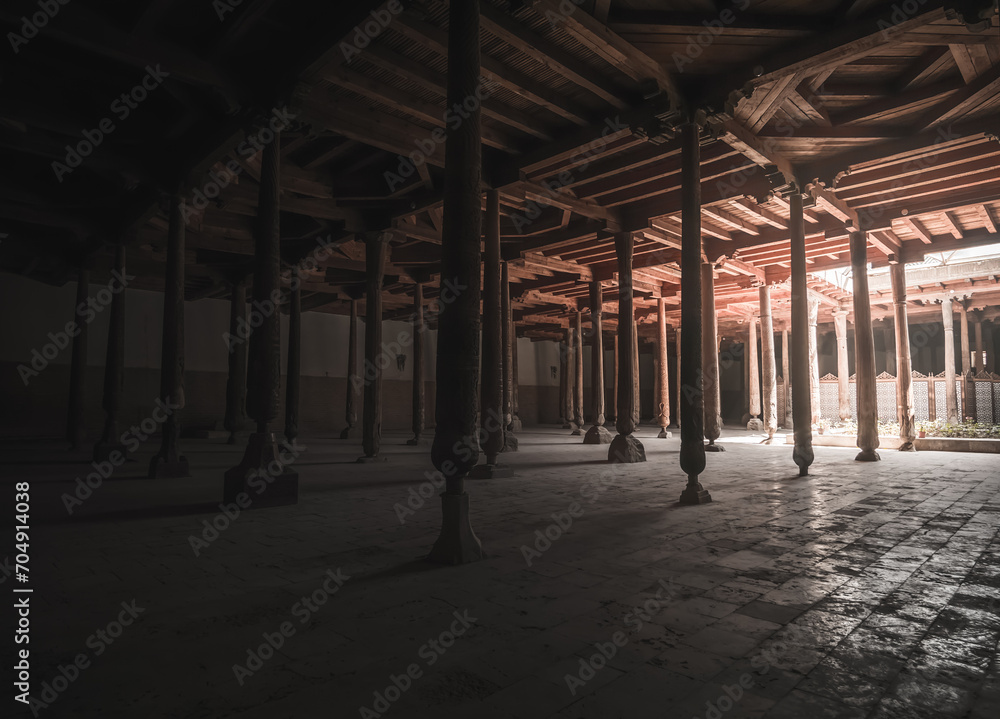 Interior inside the ancient Juma mosque with wooden carved mosaic columns, in the ancient city of Khiva in Khorezm, wood carvings on the columns