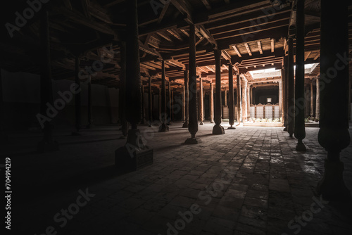 Interior inside the ancient Juma mosque with wooden carved mosaic columns, in the ancient city of Khiva in Khorezm, wood carvings on the columns photo