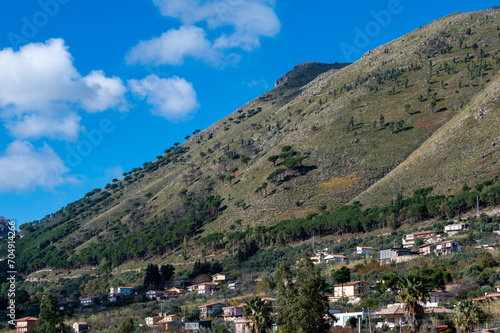 Panoramic view over the rough mountains with houses and blue sky around Cannizaro- Favare, Italy © Werner