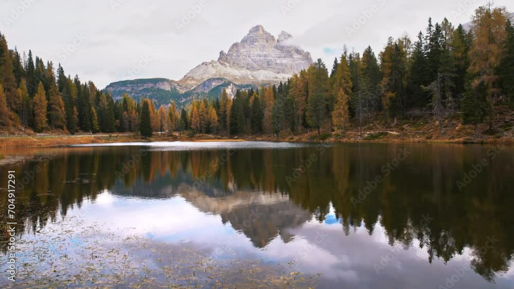 The Misurina lake surrounded by autumn forest with the Three Peaks of Lavaredo mountains in the background in Dolomites, Italy The Misurina lake surrounded by autumn forest with the Three Peaks of Lavaredo mountains in the background in Dolomites, Italy