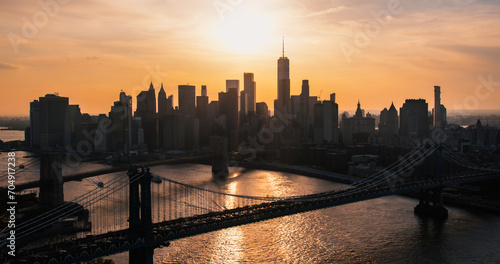 New York City Skyline Aerial Shot from a Helicopter at Sunset. Famous Skyscraper Buildings with Manhattan and Brooklyn Bridges. Busy Diverse Megapolis with Cars, Boats and People Moving Around