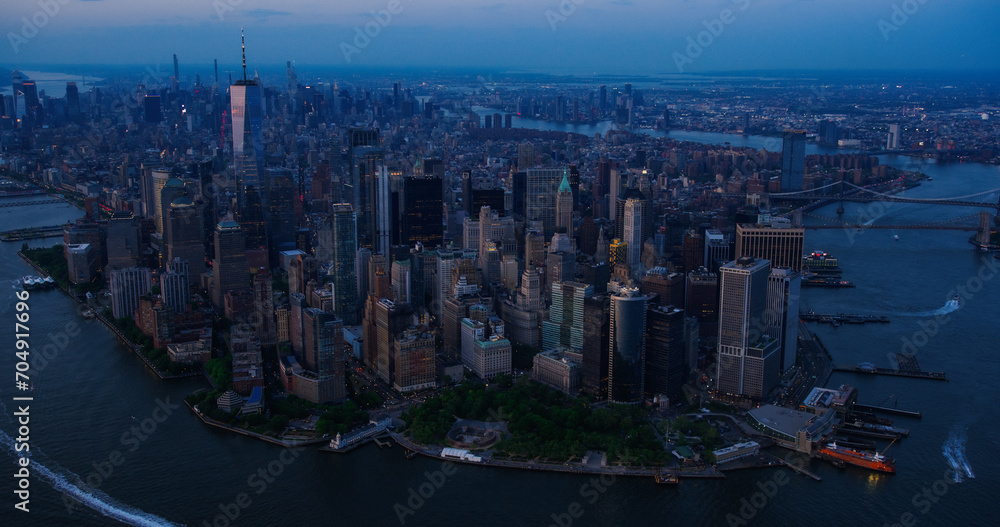 Obraz premium Evening Aerial View of Lower Manhattan Architecture. Panoramic Shot of Wall Street Financial District from a Helicopter. Office Buildings Next to Water Transportation in Hudson and East Rivers