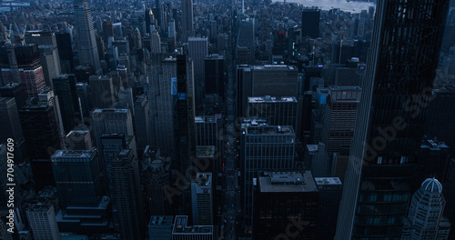 Dark Aerial Evening Photo of New York City with Straight Busy Streets with Cars and Yellow Taxi Vehicles. Lowered Helicopter View of Office Buildings and Skyscrapers in a Big Urban Center