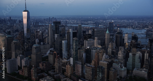 Evening Panorama Around the Wall Street Financial District in New York City, USA. Dark Aerial Photo with Lit Office Buildings and Skyscrapers on a Summer Night with Deep Blue Sky