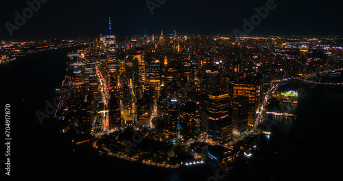 Aerial Night View of New York City Avenues in Manhattan, Business and Residential Building Roofs, Cars and Commercial Vehicles Driving at Night. Helicopter View a Straight Roads with Traffic