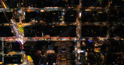Top Down Aerial View of New York City Streets Lit with Neon Lights from Billboards. Busy Metropolis Traffic with Cars  Yellow Taxis  Commercial Vehicles and People Walking
