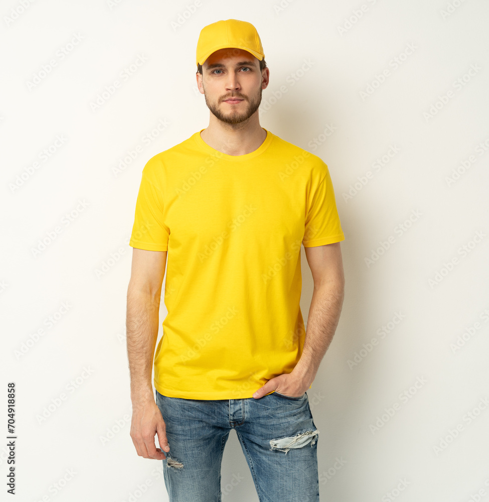 Delivery man in yellow uniform isolated on white background. Professional smiling confident male employee in cap, t-shirt courier dealer Delivery man in yellow uniform isolated on white background. Professional smiling confident male employee in cap, t-shirt courier dealer