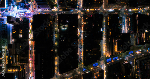 Top Down Aerial View of New York City Streets at Night with Visible Grid System, Business and Residential Building Roofs. Busy Center with Traffic, Cars, Yellow Taxis, Commercial Vehicles, Pedestrians photo