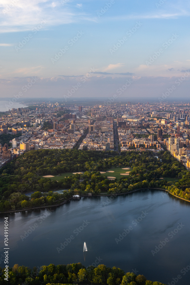 Fototapeta premium New York Cityscape During Daytime. Aerial Photo from a Helicopter. Modern Skyscraper Buildings Around Central Park in Manhattan Island. Focus on Nature, Trees and Lakes in the Park in the City
