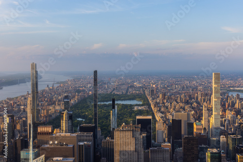 New York Cityscape at Sunset. Aerial Photo from a Helicopter. Modern Skyscraper Buildings Around Central Park in Manhattan Island. Focus on Nature, Trees and Lakes in the Park in the City