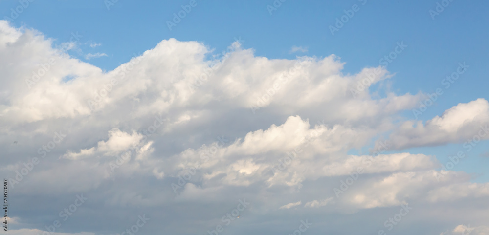 Fluffy cumulus clouds in summer day. Atmosphere background or wallpaper