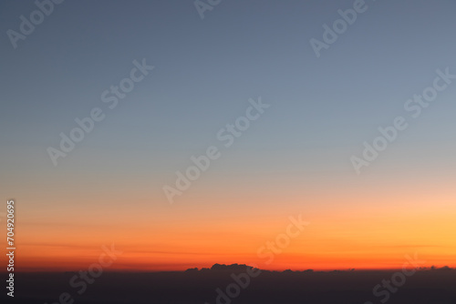 Heaven at early morning with copy space. Sunset, sunrise backdrop.Predawn clear sky with orange horizon and blue atmosphere. Smooth orange blue gradient of dawn sky.