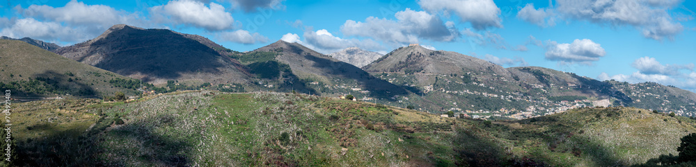 Extra large panoramic view over the rough mountains with houses and blue sky around Cannizzaro-Favare, Italy