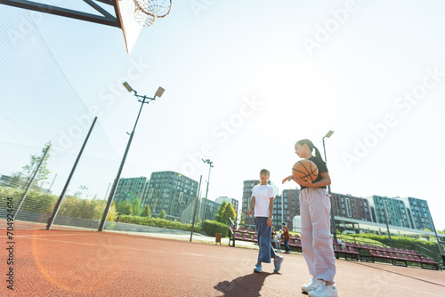Canvas Print children schoolchildren playing a match about basketball against the background