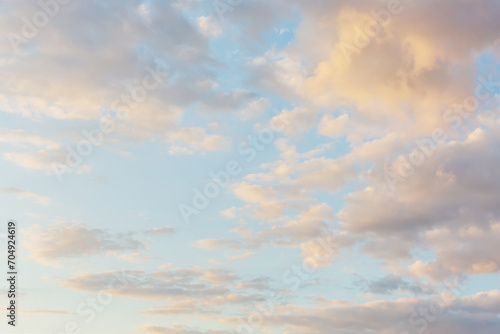 Beautiful fluffy clouds painted in pastel colors at sunrise. Multicolor sky atmosphere background or wallpaper