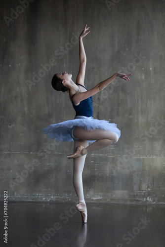 Young ballerina in a white tutu in a graceful pose