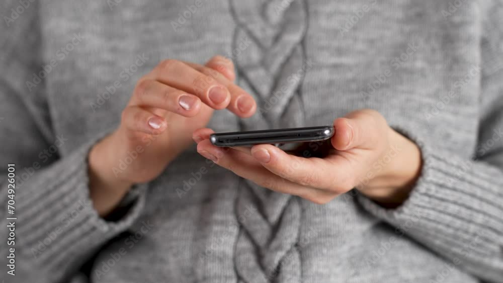 Woman hand using phone, indoors. Woman holding smartphone
