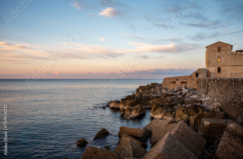 Golden hour at the pier and rocks of the village Cefaly, Sicily, Italy