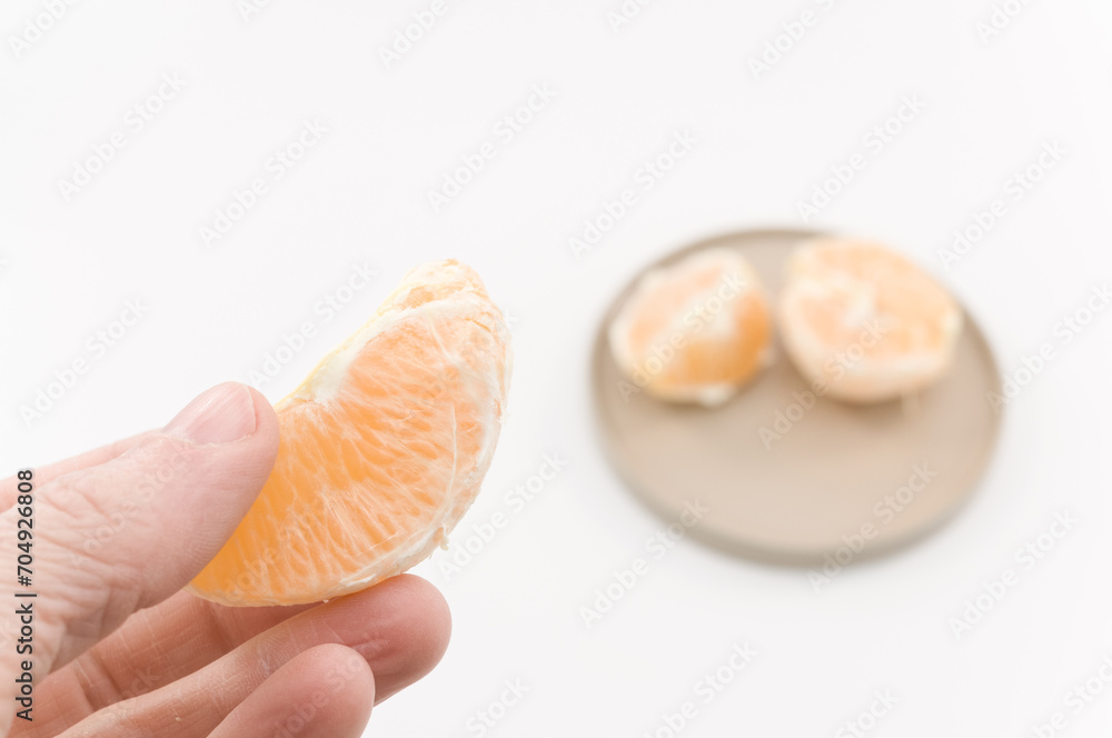 immagine con primo piano di mano che regge frutti di arancia, clementina su superficie bianca immagine con primo piano di mano che regge frutti di arancia, clementina su superficie bianca