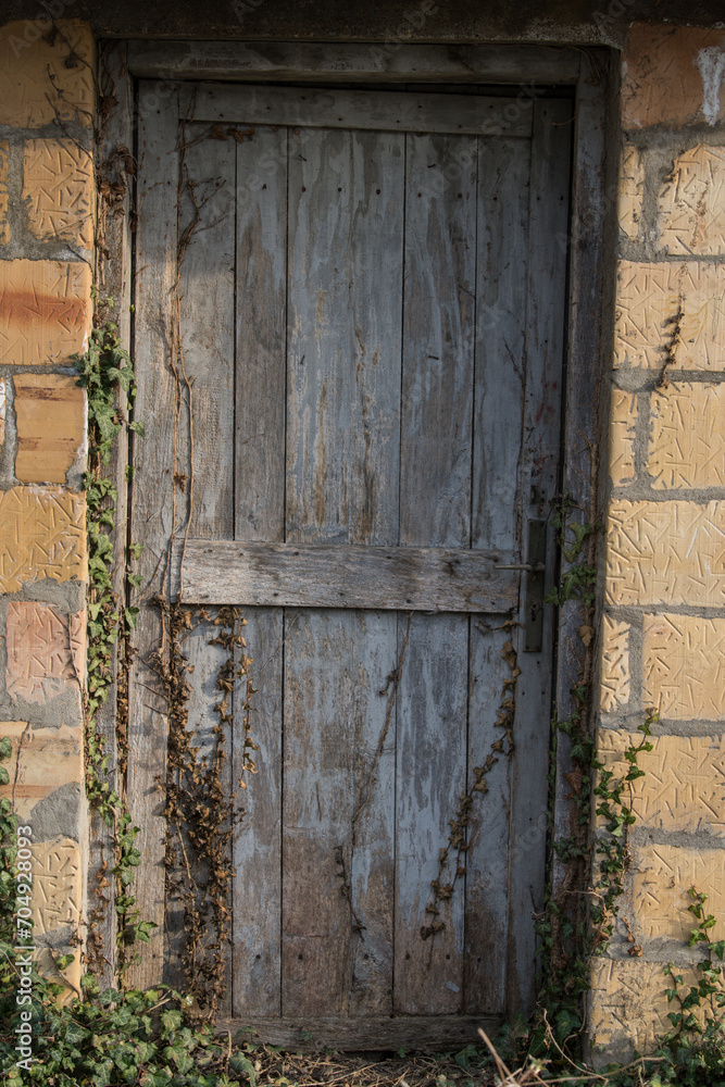 Sunja , Croatia, 05,04,2021: Old wooden rustic door on rural home wall. Sunja , Croatia, 05,04,2021: Old wooden rustic door on rural home wall.