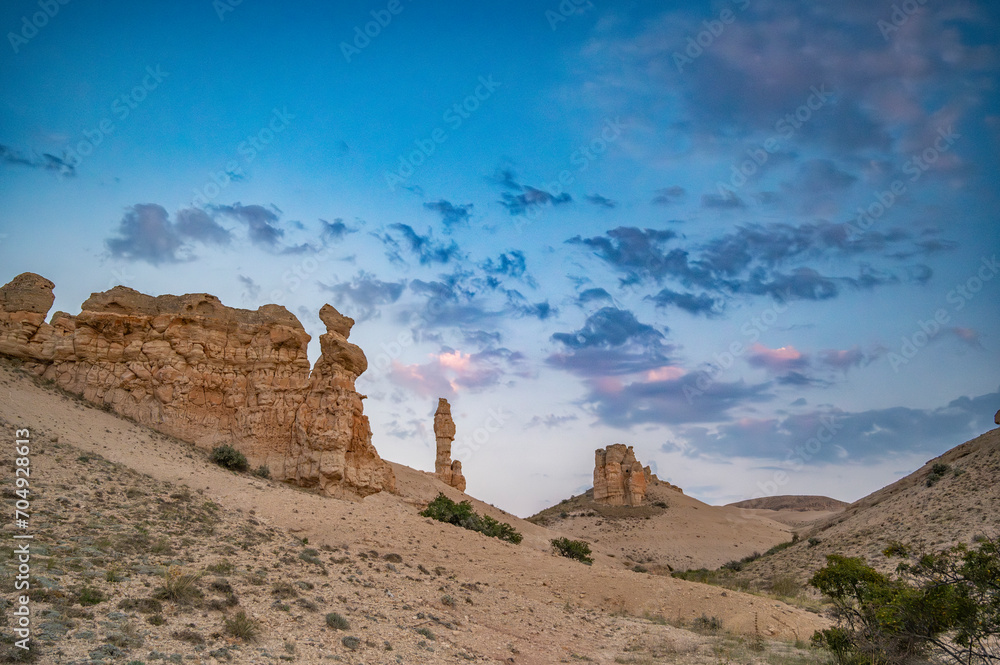Unique rock forms in the middle of deserted nature with sunset colors and clouds in the sky