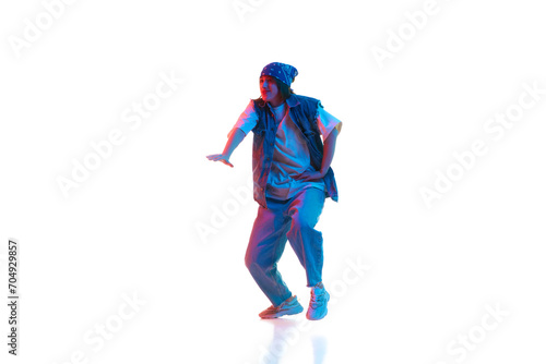 Dynamic image of young girl in casual sportive cloths dancing hip hop isolated over white background in neon light. Concept of contemporary dance, street style, youth, hobby, action, lifestyle © master1305