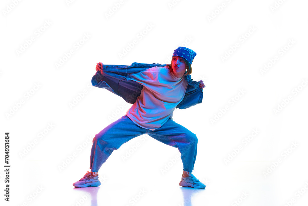 Dynamic image of young girl in casual sportive cloths dancing hip hop isolated over white background in neon light. Concept of contemporary dance, street style, youth, hobby, action, lifestyle Dynamic image of young girl in casual sportive cloths dancing hip hop isolated over white background in neon light. Concept of contemporary dance, street style, youth, hobby, action, lifestyle