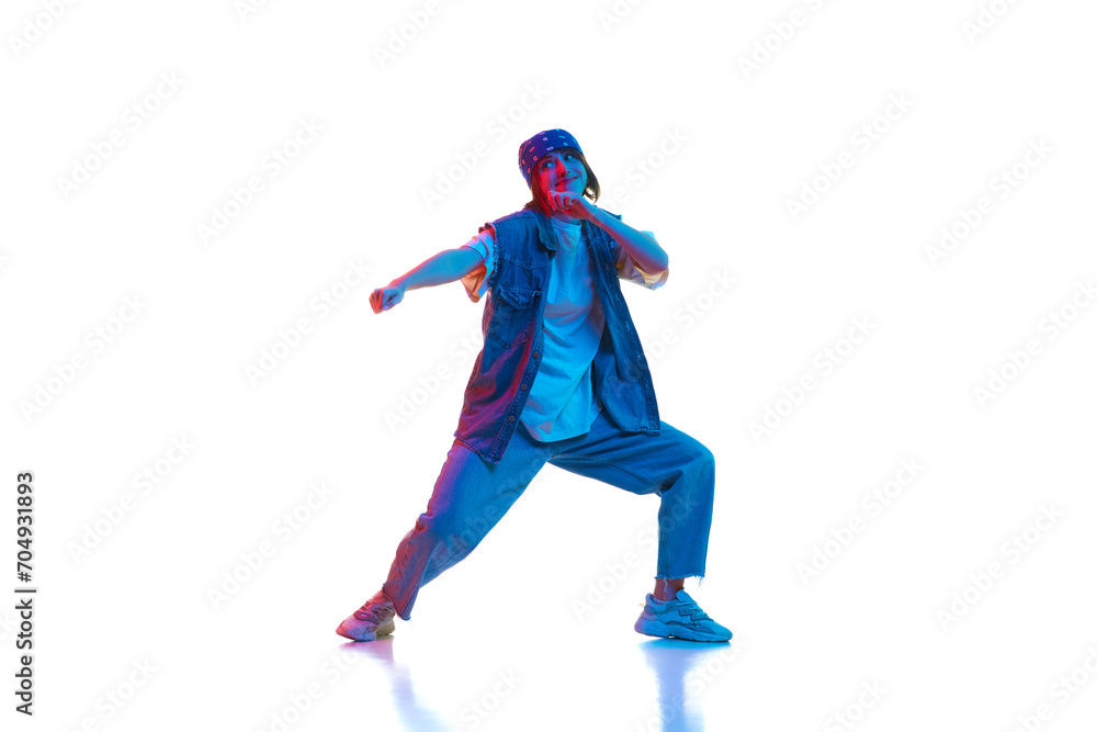 Hip hop, contemp, dance hall, street style dancer. Young girl in motion dancing isolated over white background in neon light. Concept of contemporary dance, style, youth, hobby, action, lifestyle