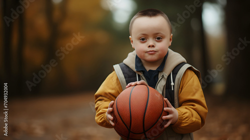 Little boy with down syndrome holds a basketball