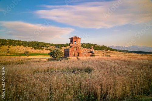Red church ruins in Nigde province, sunset colors and clouds in the sky photo