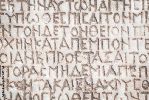 Retro text background. Fragment of ancient inscription (imperial law in ancient Greek language), carved on marble block. Monochrome. Ancient Miletus, Turkey (Turkiye). Ancient art and history concept photo