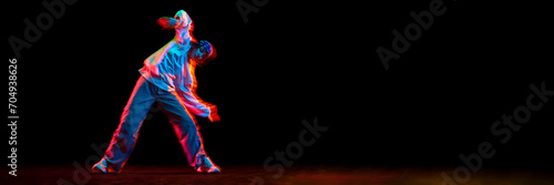 Wallpaper Mural Young girl, hip hop dancer in motion, dancing isolated over black background in neon light. Concept of contemporary dance, street style, youth, hobby, lifestyle. Banner. Empty space to insert text Torontodigital.ca
