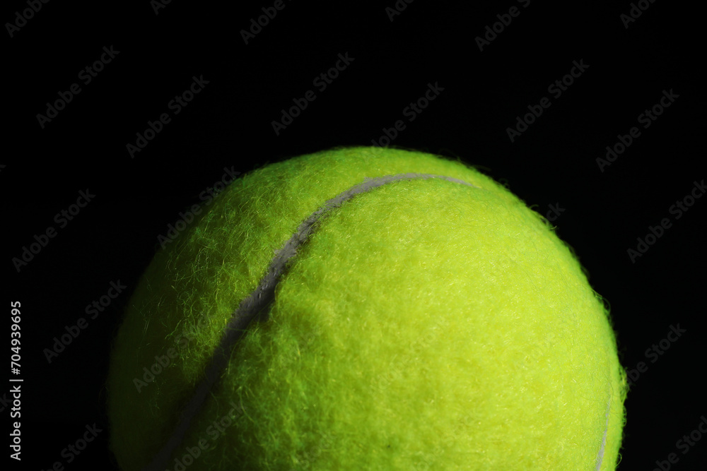 One tennis ball on black background, closeup