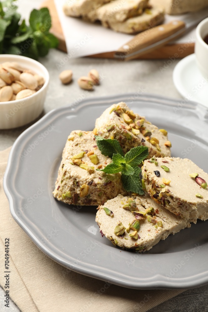 Tasty halva with pistachios and mint on table, closeup Tasty halva with pistachios and mint on table, closeup