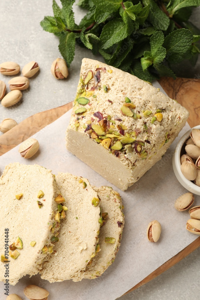 Tasty halva with pistachios and mint on light grey table, top view Tasty halva with pistachios and mint on light grey table, top view