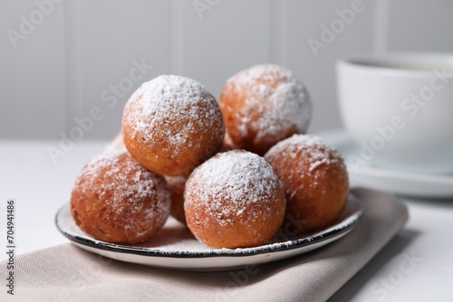 Delicious sweet buns with powdered sugar on table