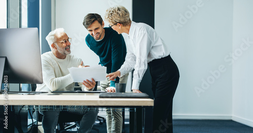 Three business people having a discussion as a team in an office photo