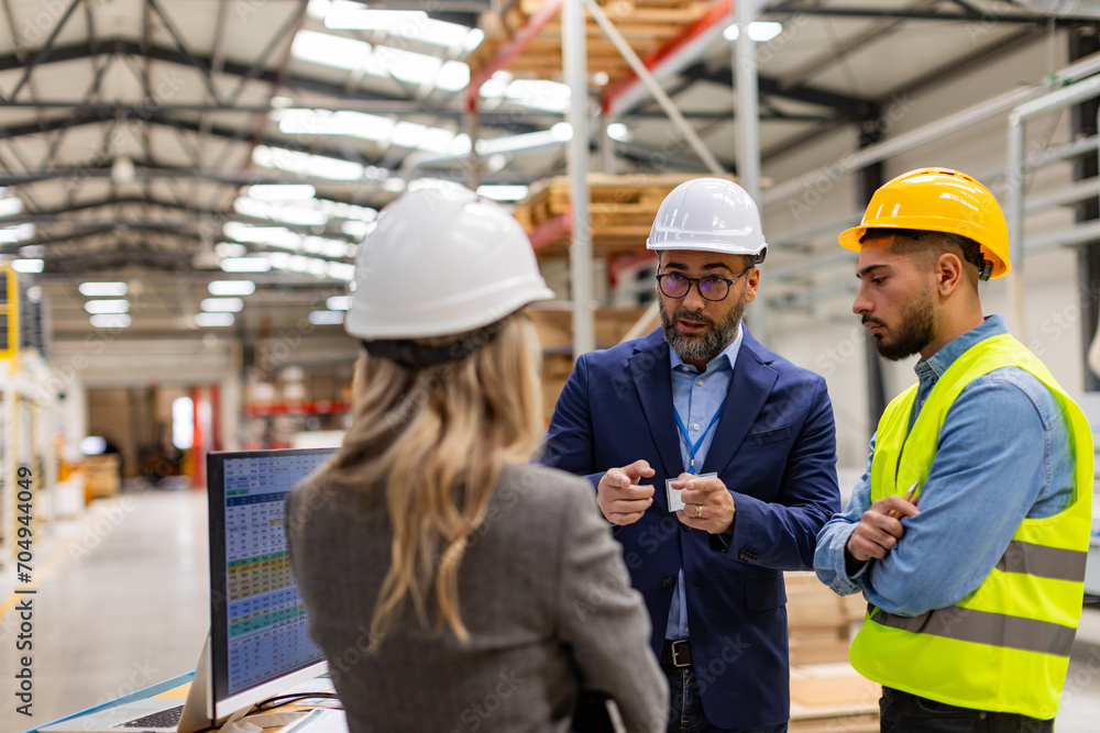 Engineer, foreman consulting with director in modern industrial factory, talking about new production project or investment. Team management in manufacturing facility.