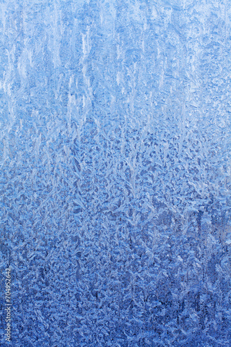 blue frosty patterns on frozen window glass