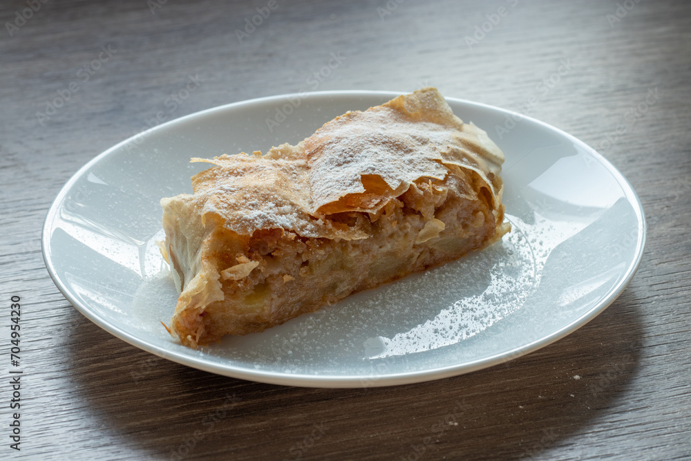 Fresh Hungarian apple strudel on a white plate on the kitchen counter