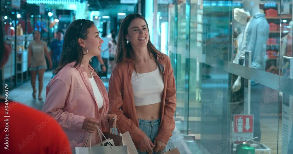 Two women at shopping center looking at showcases discussing potential purchases. Showcases spark joy conversations about new clothing Showcases playground of shopping happiness spending. Two women at shopping center looking at showcases discussing potential purchases. Showcases spark joy conversations about new clothing Showcases playground of shopping happiness spending.