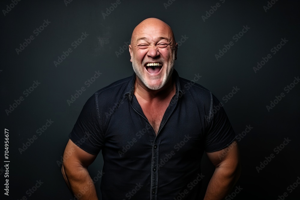 Portrait of a happy senior man laughing against a dark background. Portrait of a happy senior man laughing against a dark background.