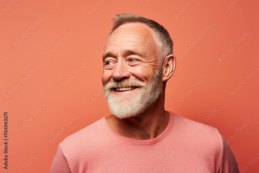 Portrait of happy senior man in pink t-shirt. Isolated on orange background. Portrait of happy senior man in pink t-shirt. Isolated on orange background.